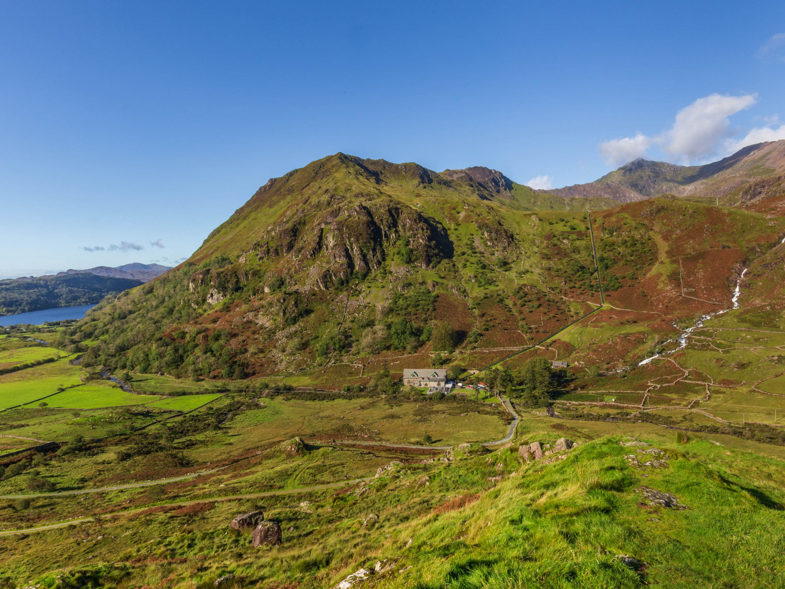 Вид на покрытую зеленью гору под голубым небом