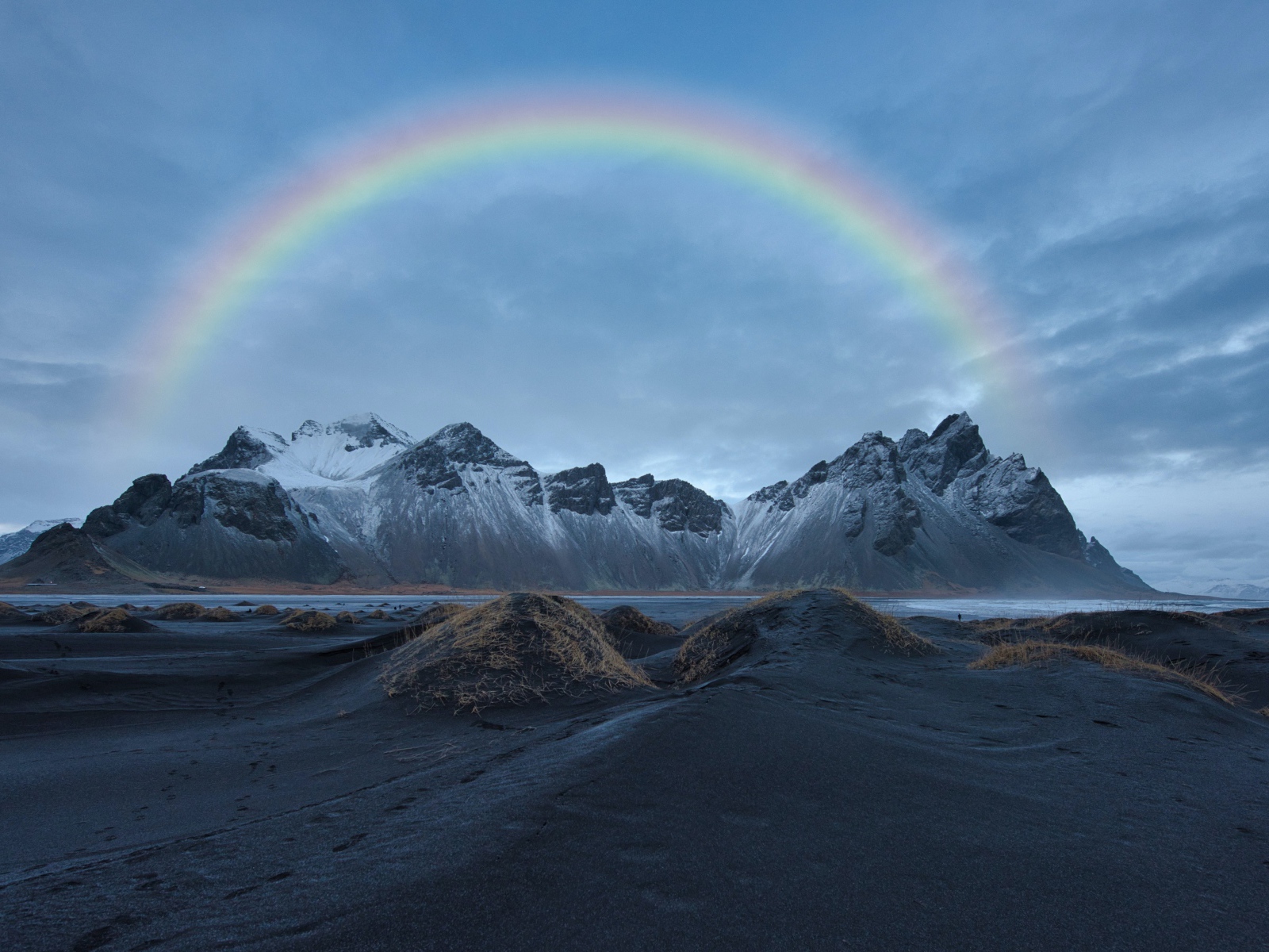 Радуга в небе над высокими горами