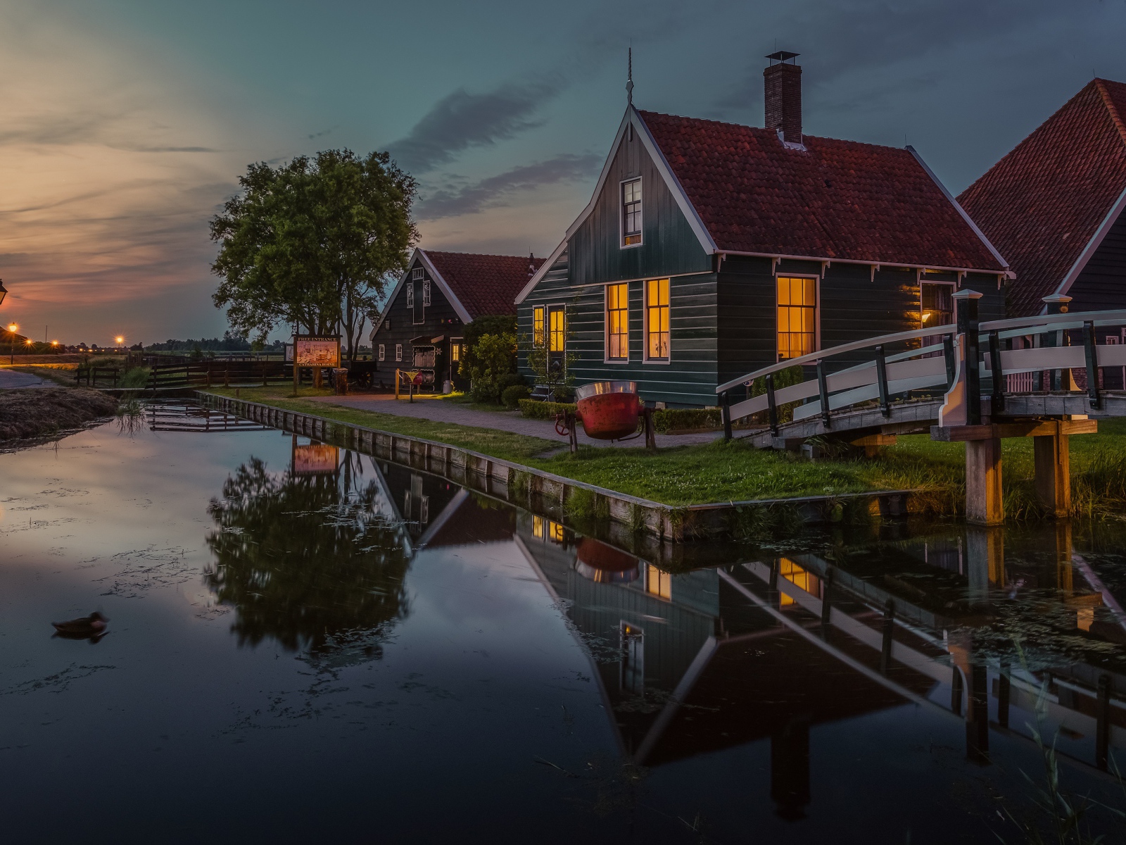 Маленькие дома у пруда вечером 