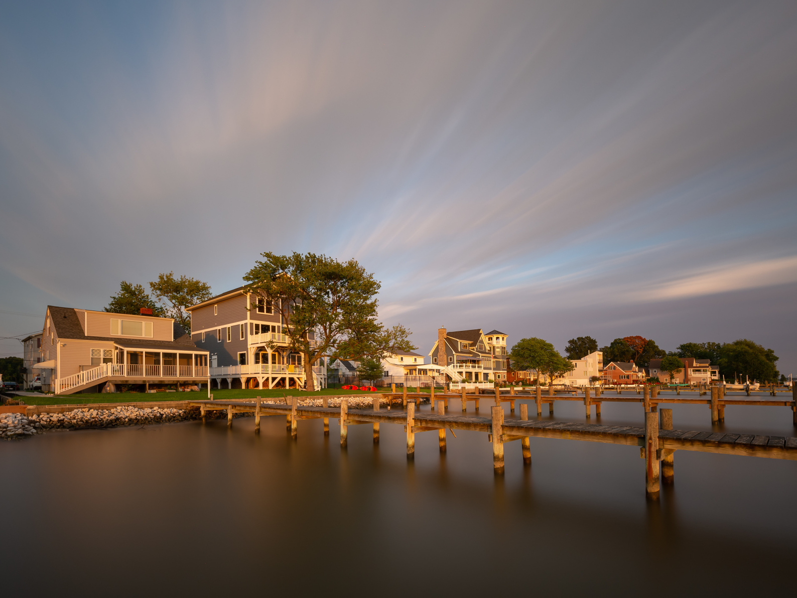 Мост у дома над тихой рекой под красивым небом