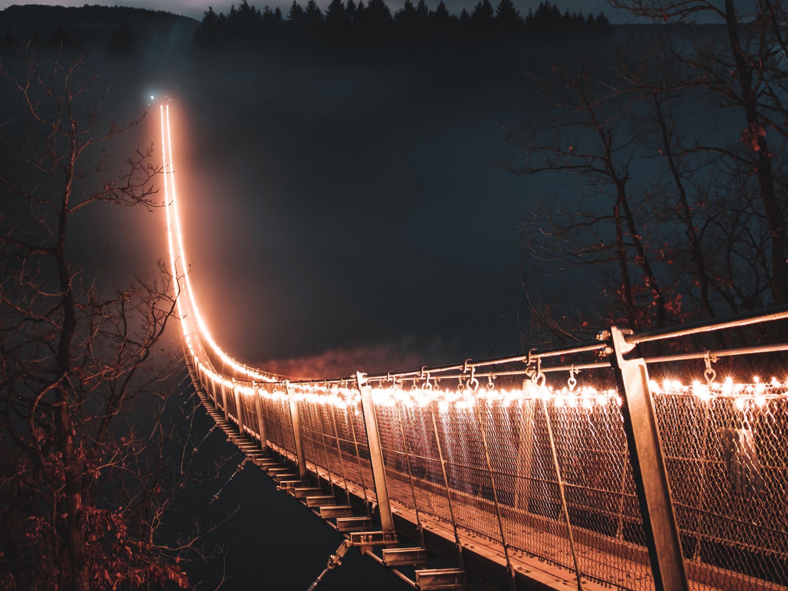 Мост с фонарями через реку в тумане ночью 
