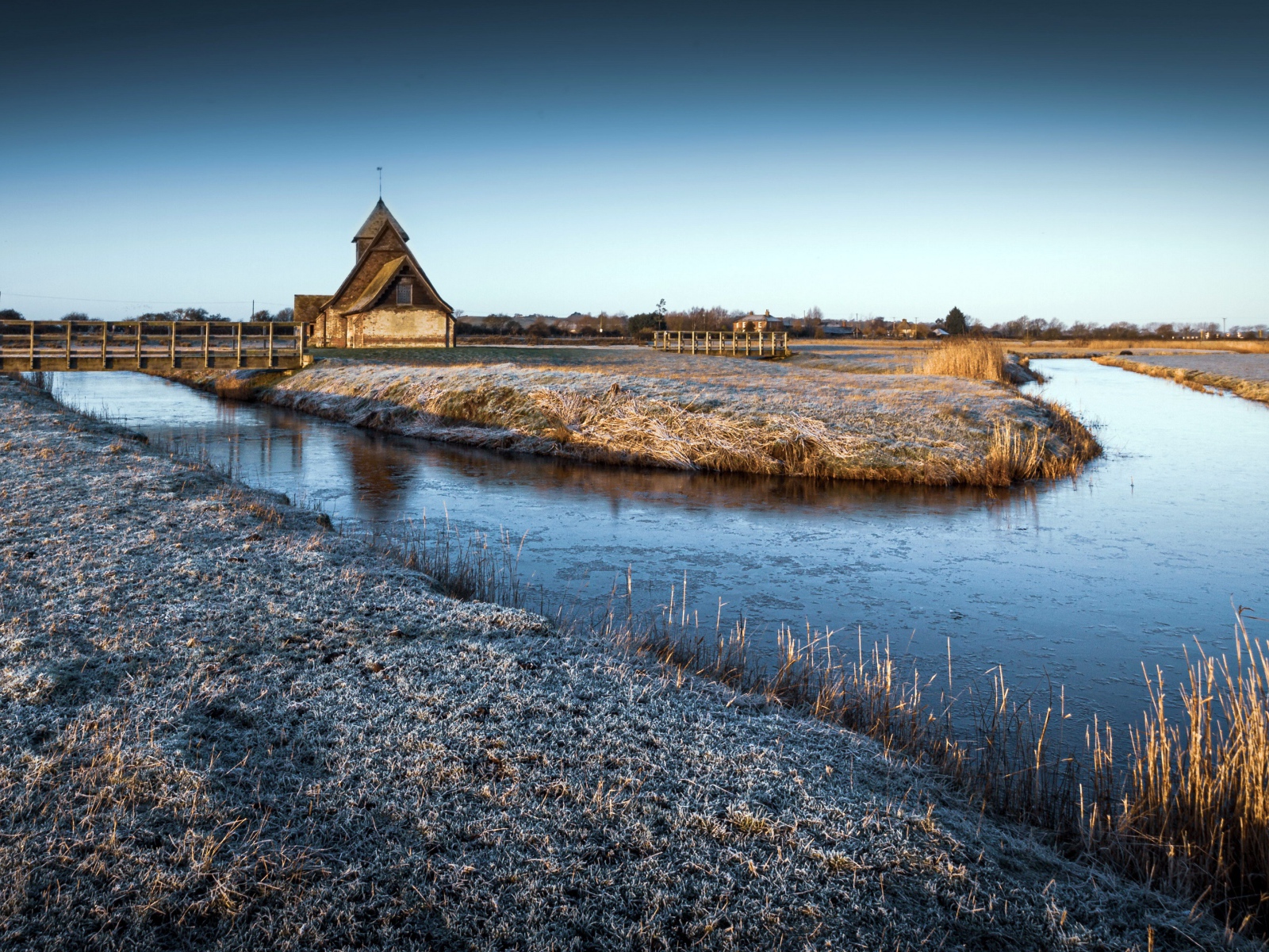 Иней покрывает землю холодным утром у реки