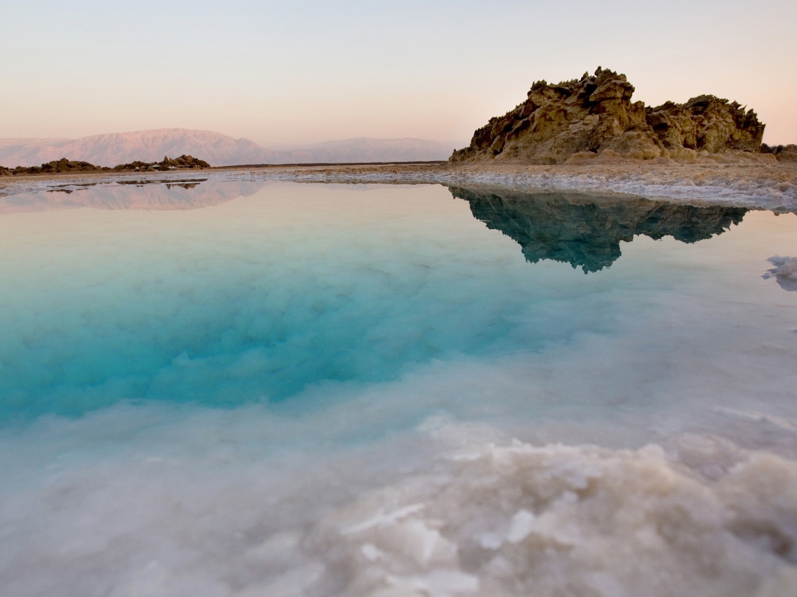 Покрытые льдом берега горного озера с голубой водой