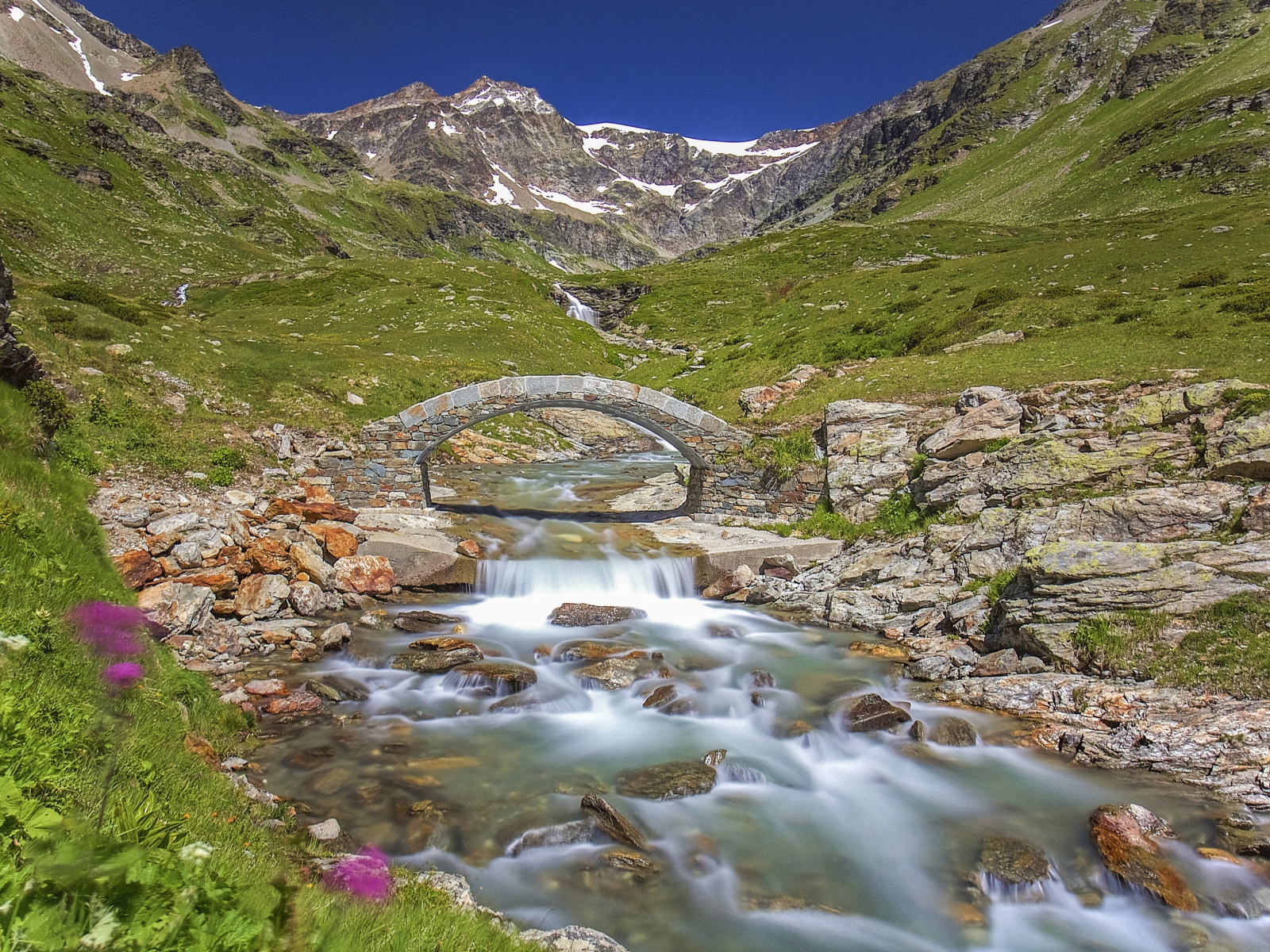 Маленький каменный мост через горную реку 