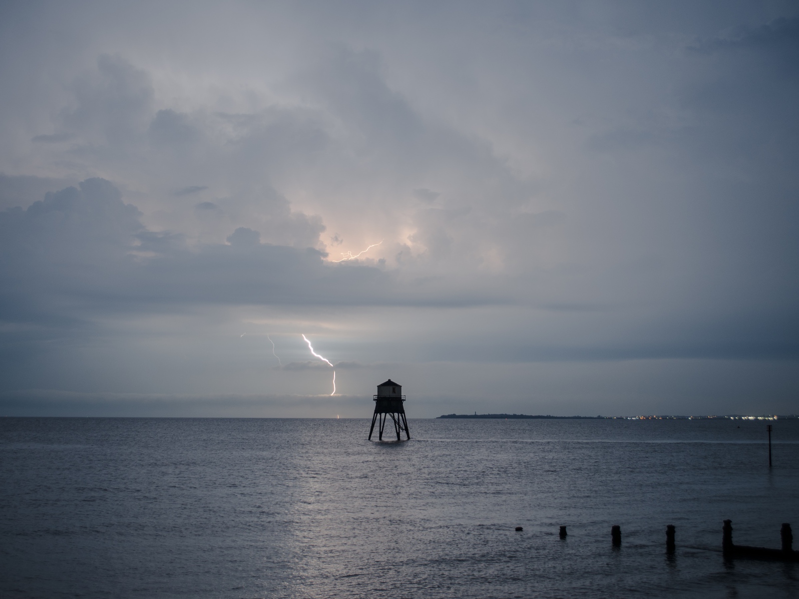 Старая башня в море на фоне грозы 