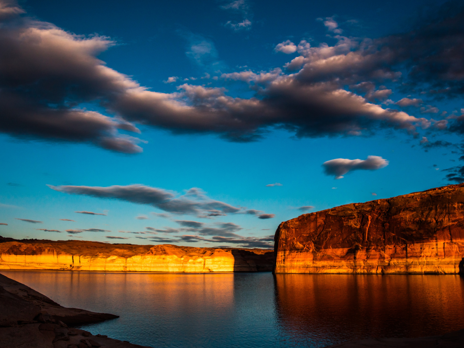 Скалы  в воде под голубым небом с облаками 