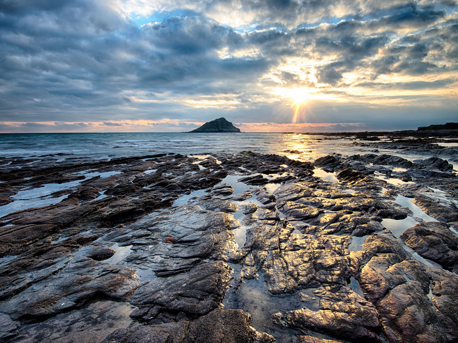 Каменный берег океана в лучах солнца