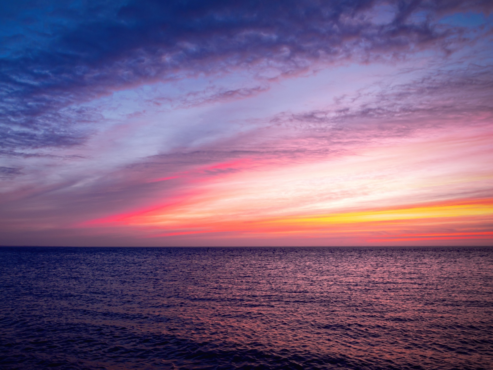 Красивый розовый закат в небе над тихим морем