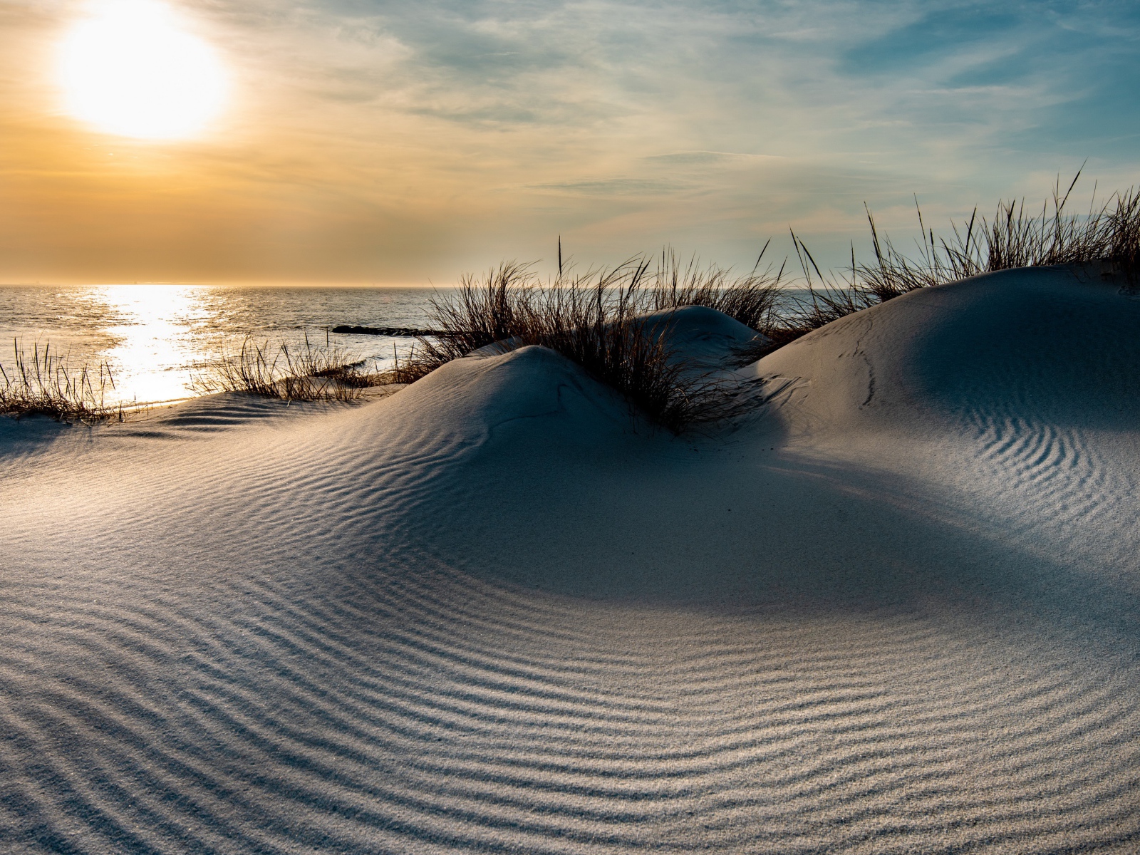 Горячий песок на берегу моря на закате 