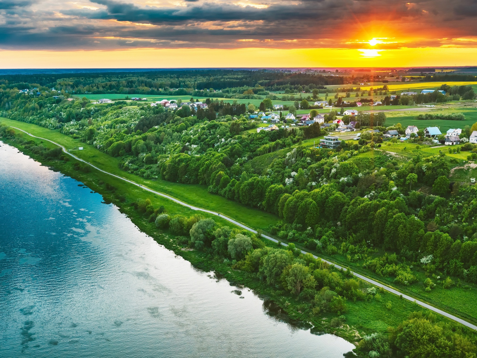Закат солнца над городом у реки, вид с высоты 