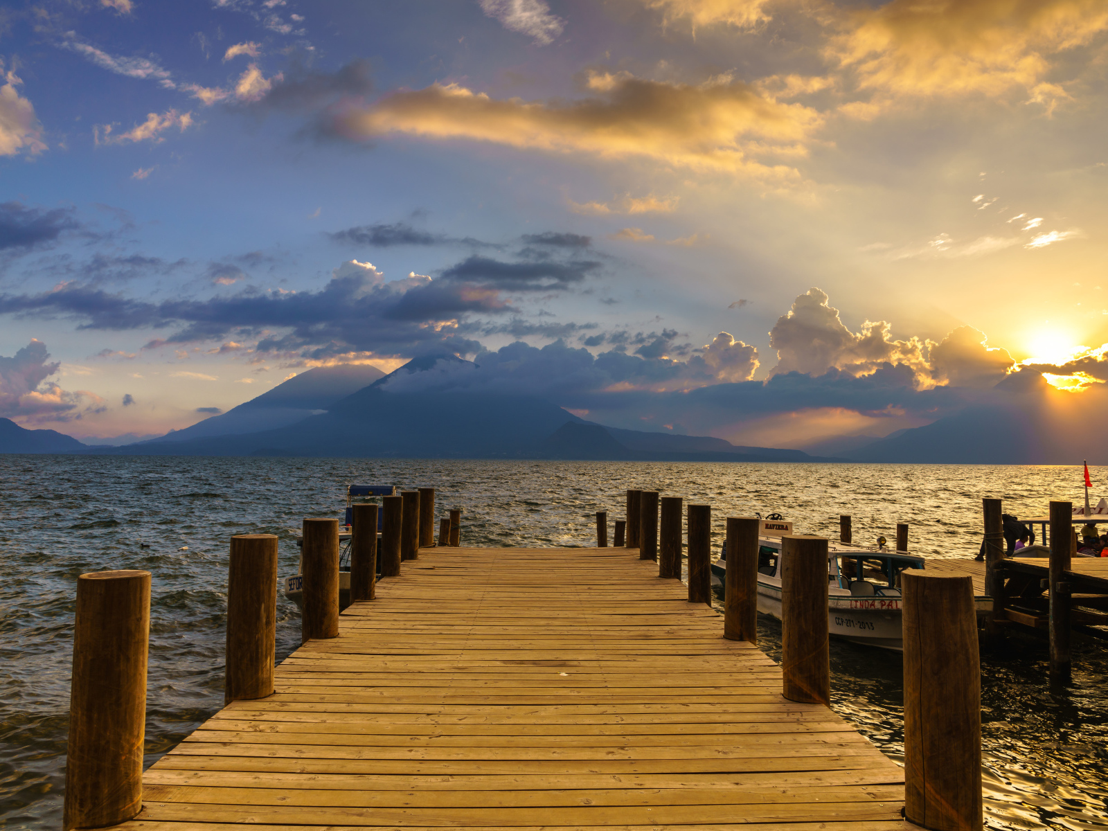 Деревянный мост в море на закате солнца 