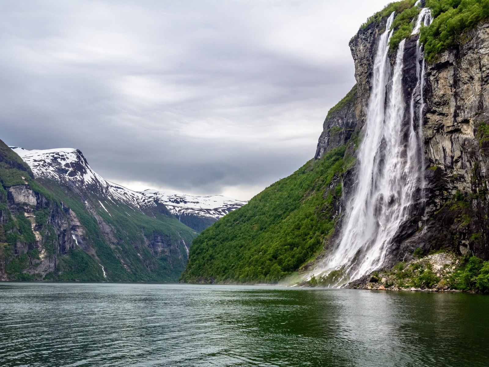 Водопад стекает с утеса в озеро, Норвегия