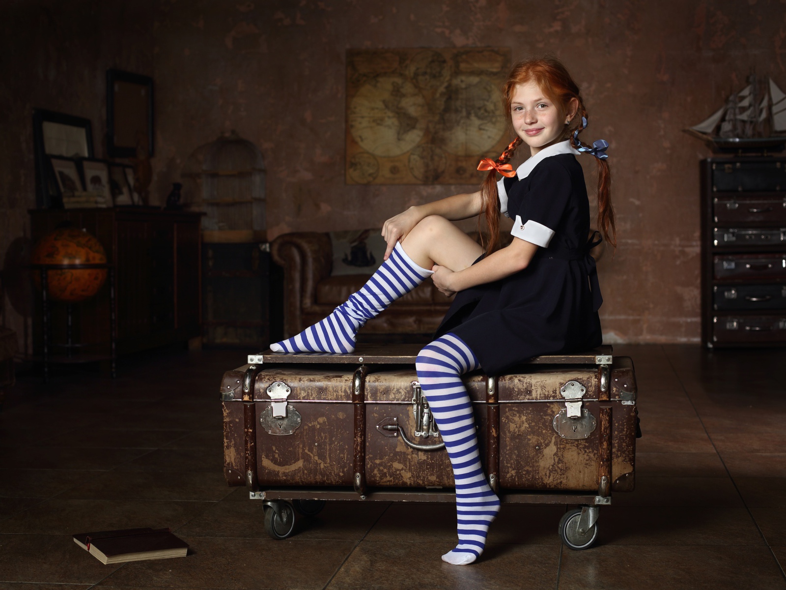 Девочка в школьной форме сидит на чемодане 