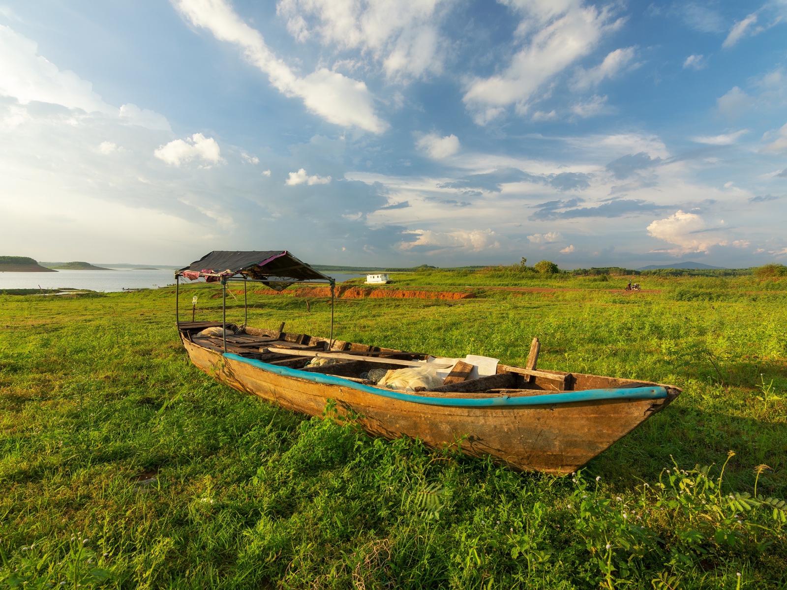 Большая деревянная лодка на зеленой траве