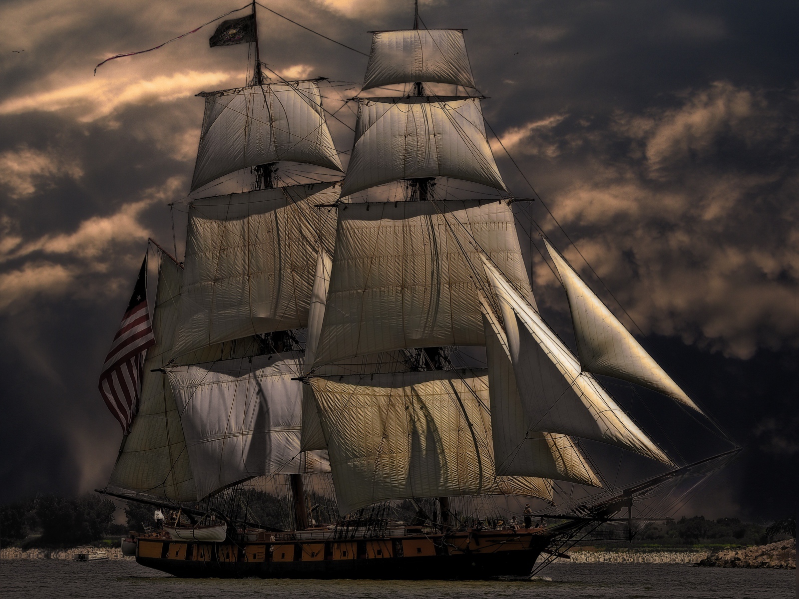 Больше судно с белыми парусами на фоне неба в сумерках 