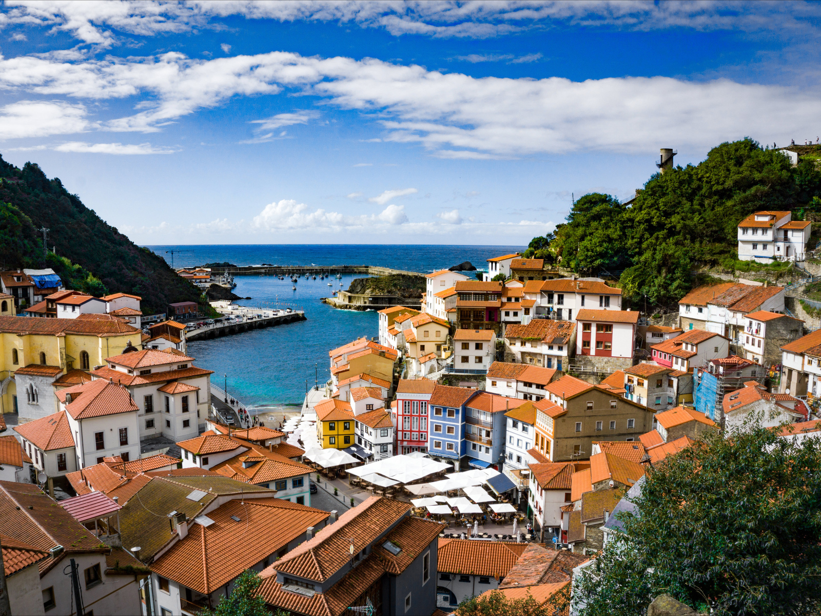 Дома в населенном пункте Кудильеро под голубым небом у залива, Испания