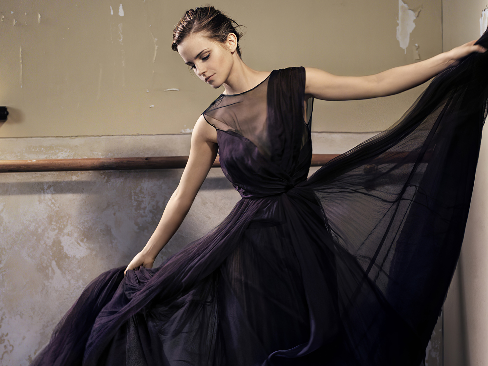 Актриса Эмма Уотсон в красивом черном платье в зале