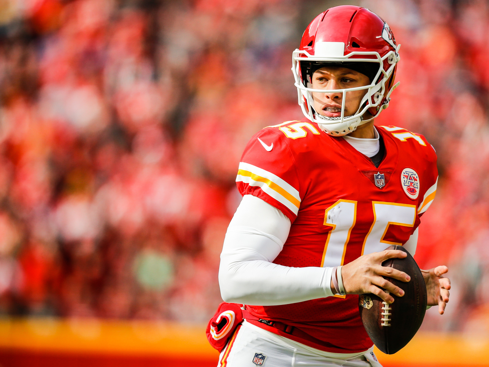 Игрок в американский футбол Патрик Махоумс на поле с мячом