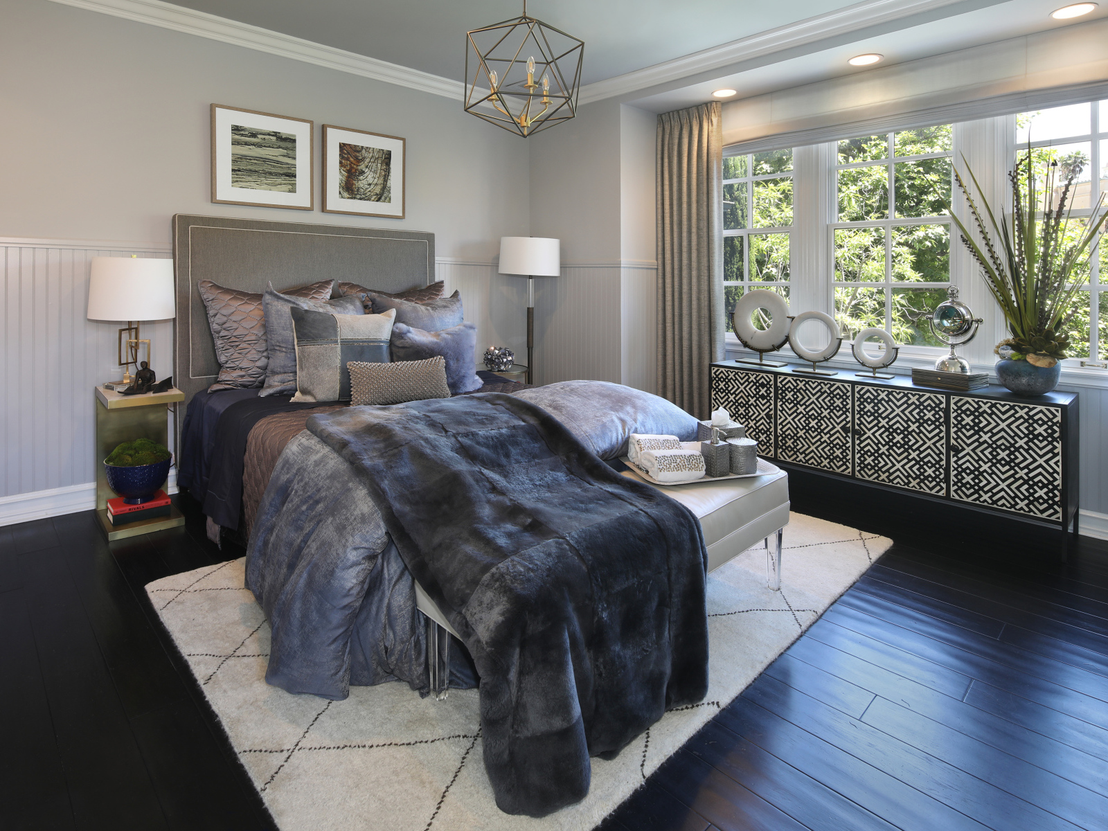 Большая кровать с мягким серым покрывалом в спальне 