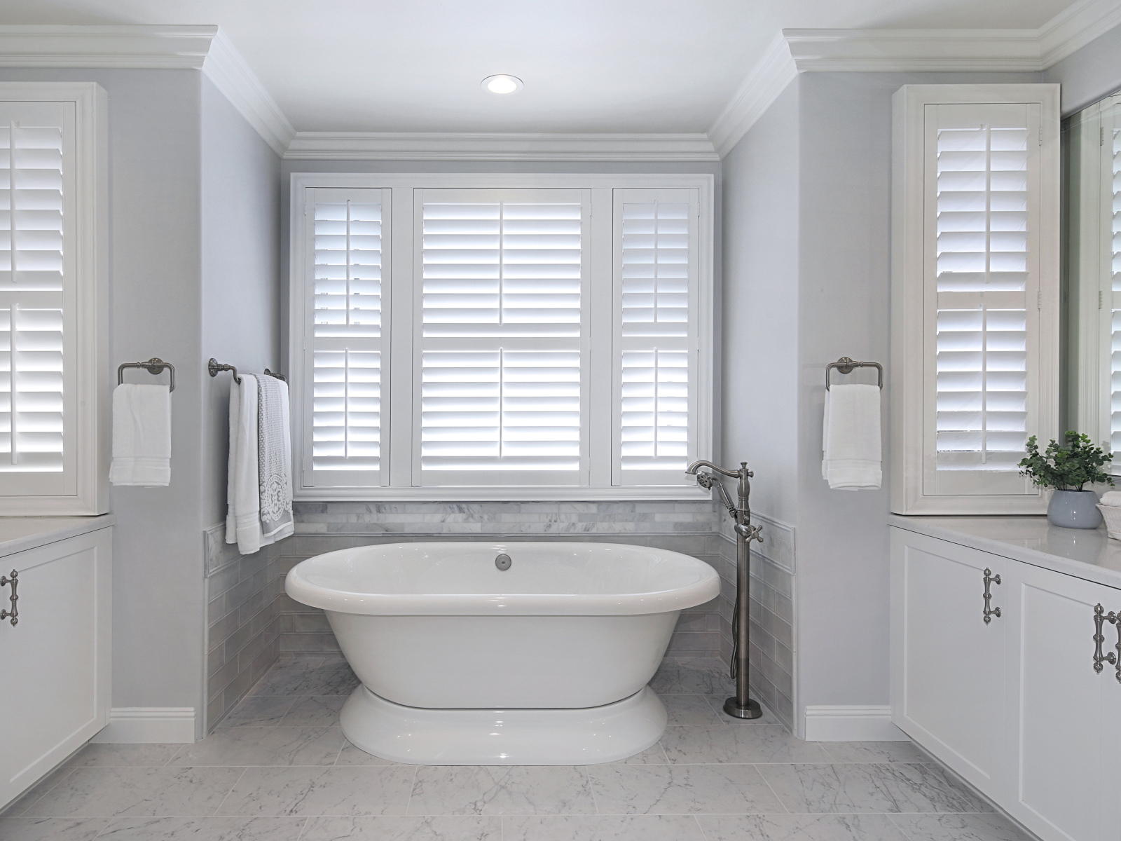 Большая белая ванна в комнате с окнами