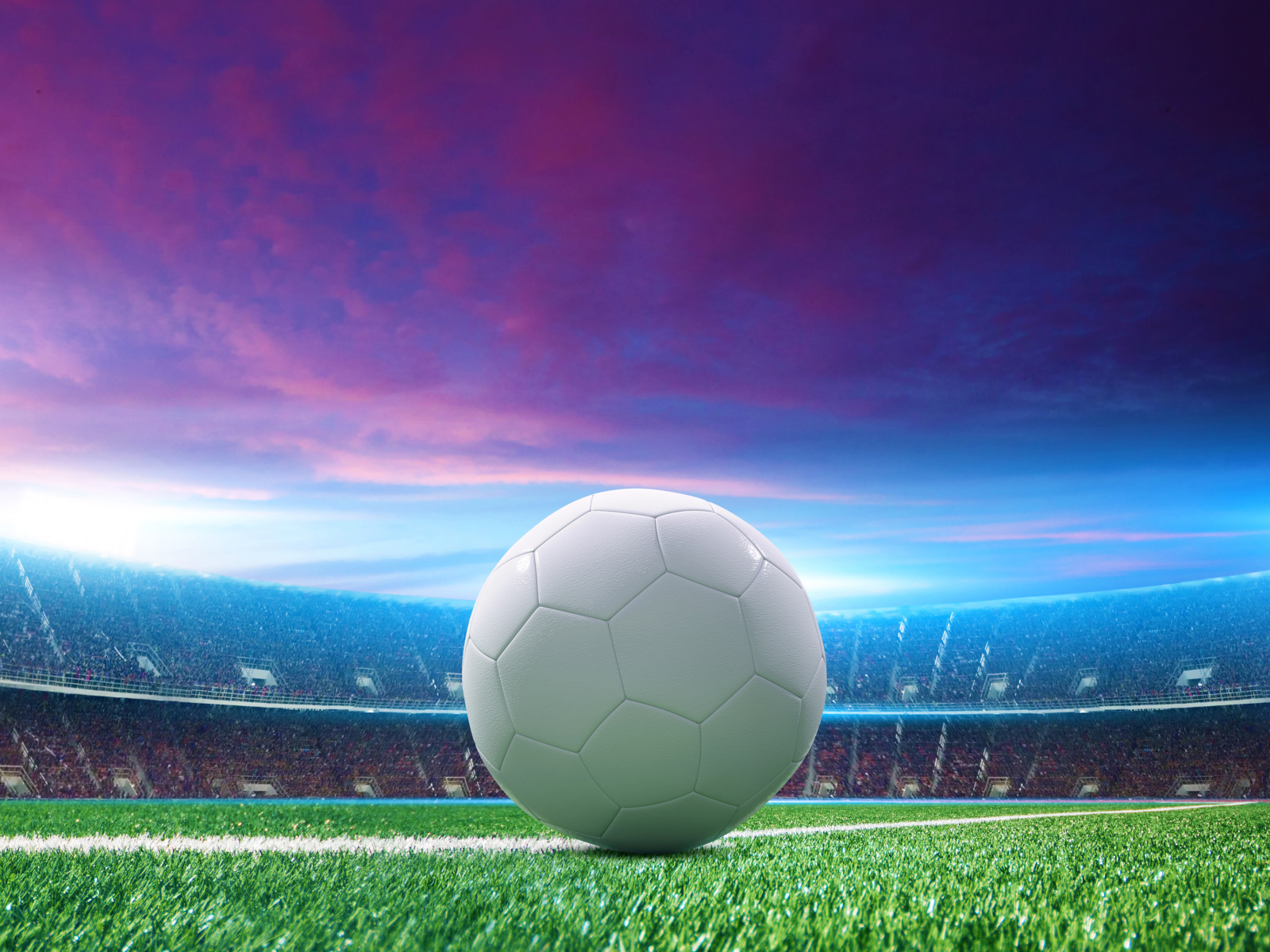 Белый футбольный мяч на зеленой траве на стадионе 