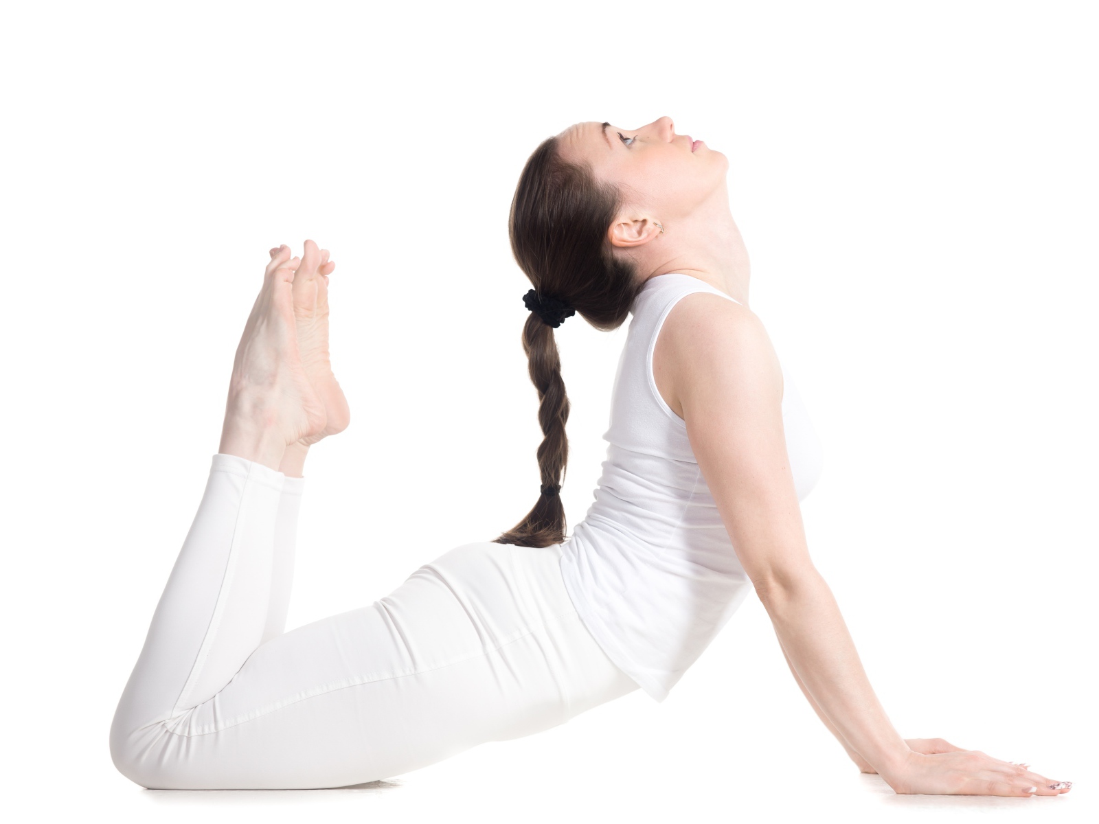 Молодая девушка делает растяжку на белом фоне