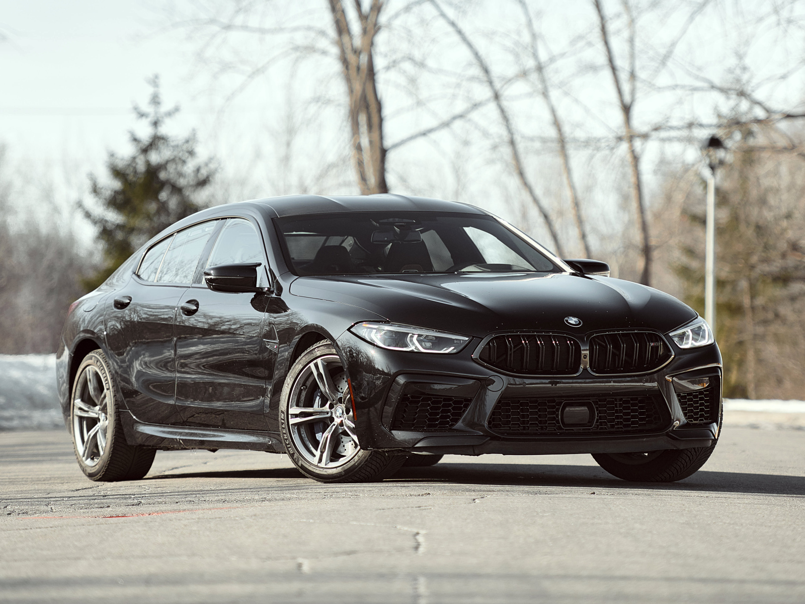 Черный автомобиль BMW M8 в лучах солнца