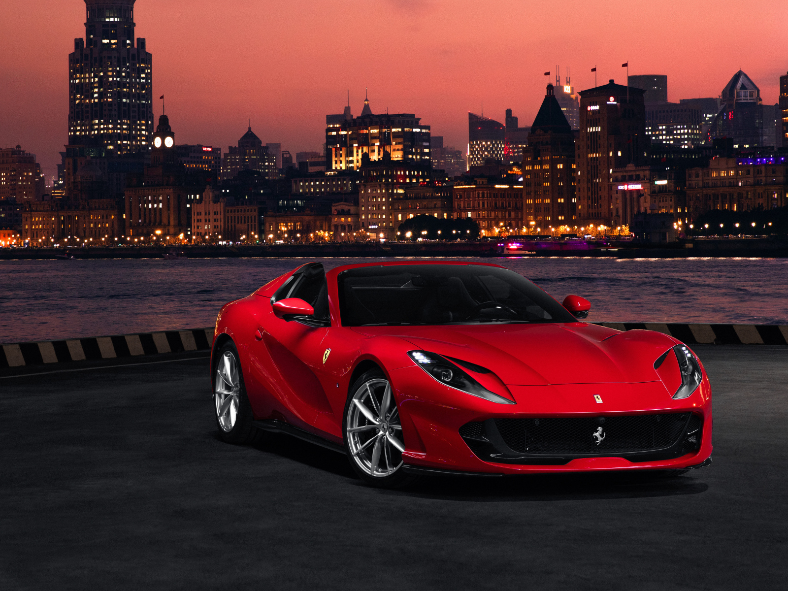 Красный автомобиль Ferrari 812 GTS  на фоне ночного города