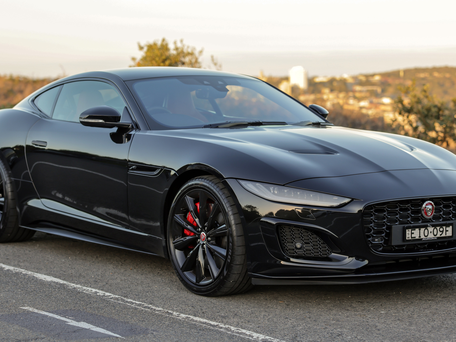 Дорогой черный автомобиль Jaguar F-Type R на дороге