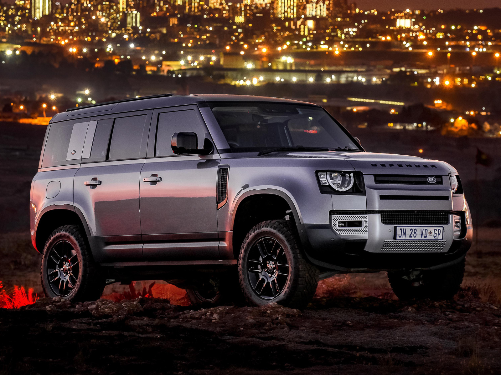 Серебристый внедорожник Land Rover Defender 110 P400 S Urban Pack 2021 года на фоне города