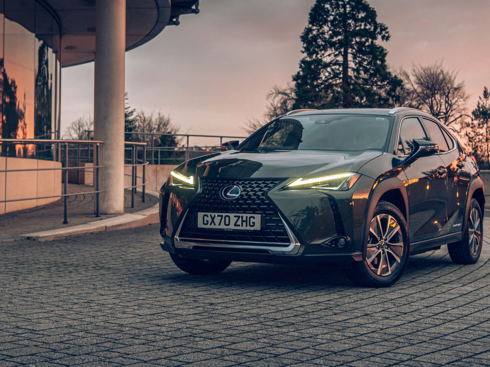 Автомобиль Lexus UX 300e 2021 года с включенными фарами