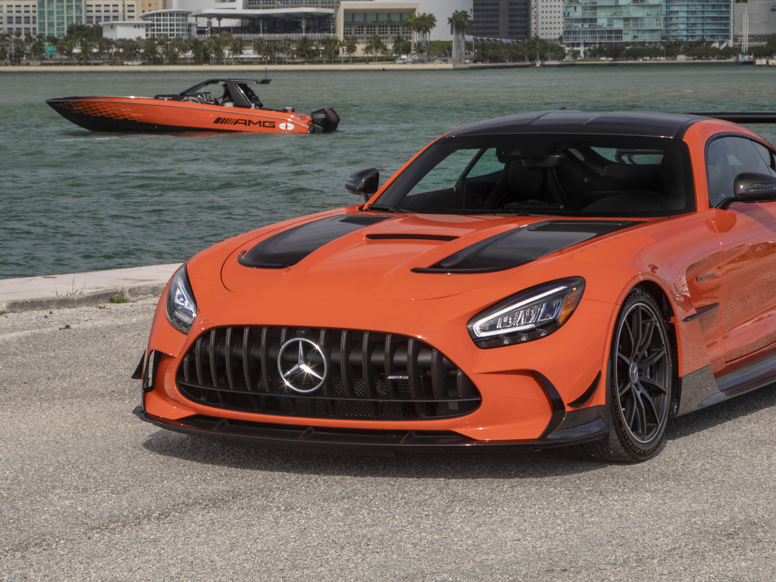 Оранжевый автомобиль Mercedes-AMG GT Black Series 2021 года у воды