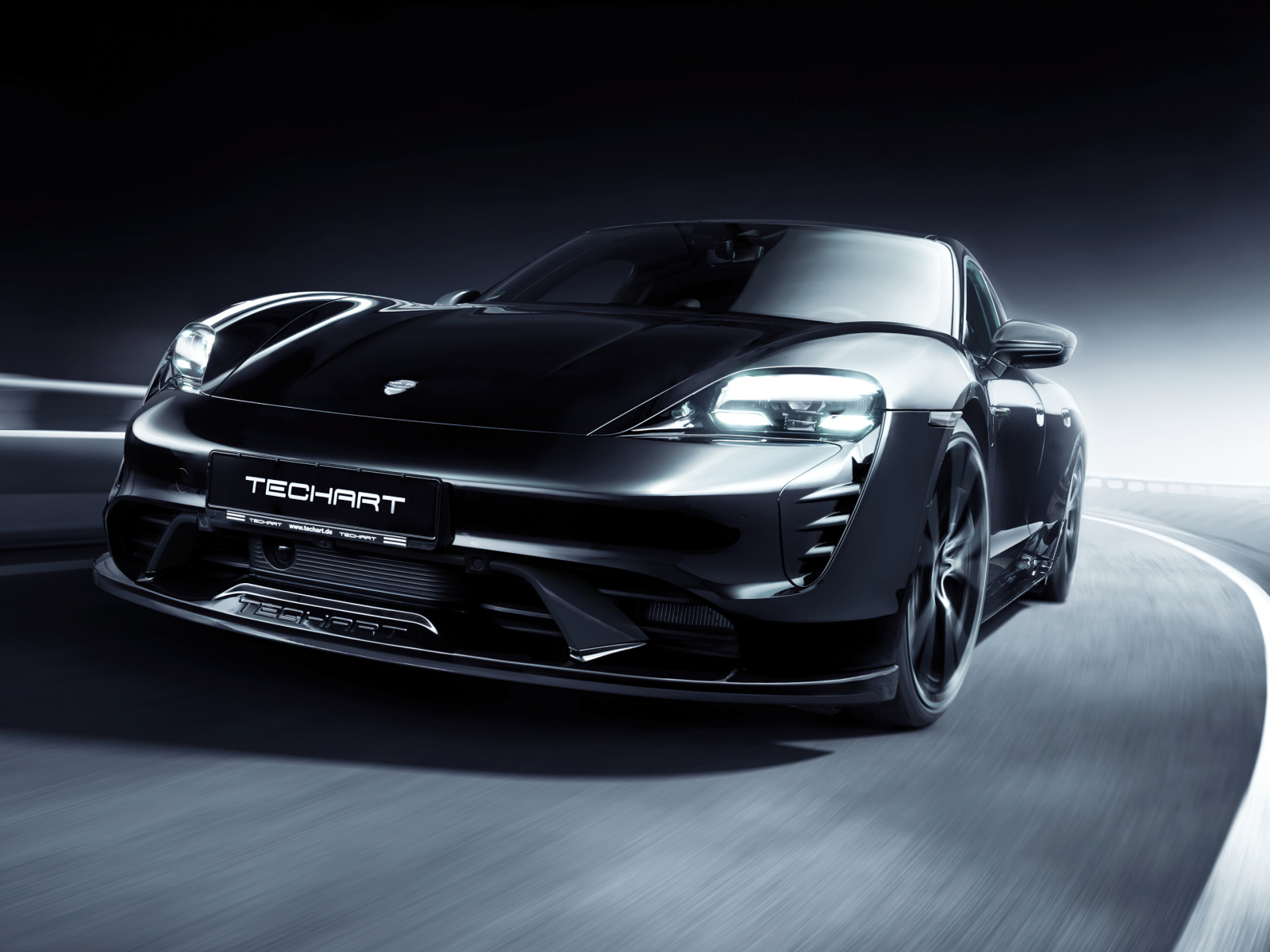 Черный Porsche Taycan Aerokit 2021 года на трассе