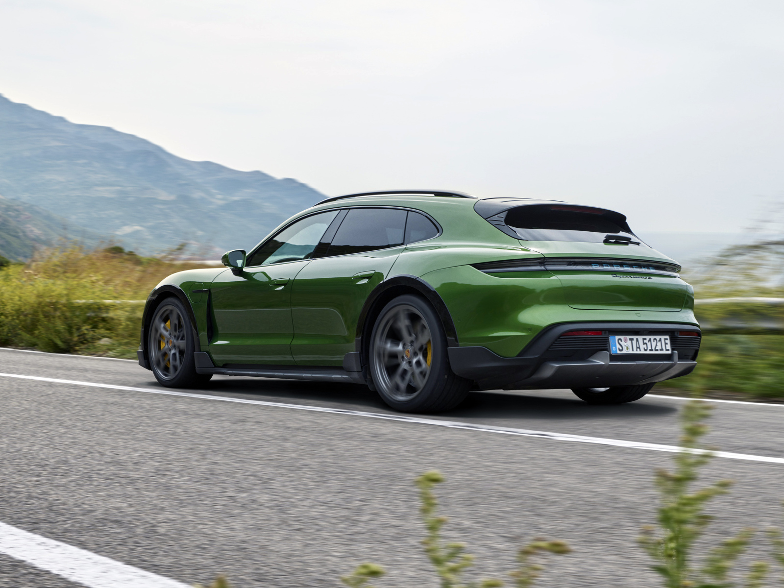 Зеленый автомобиль Porsche Taycan Turbo S Cross Turismo 2021 года вид сзади