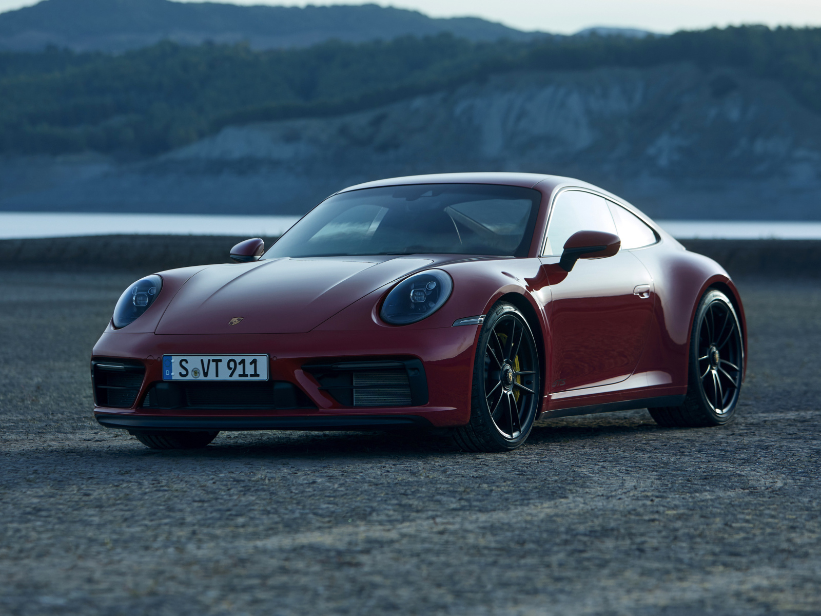 Красный Porsche 911 Carrera GTS 2021 года на фоне гор