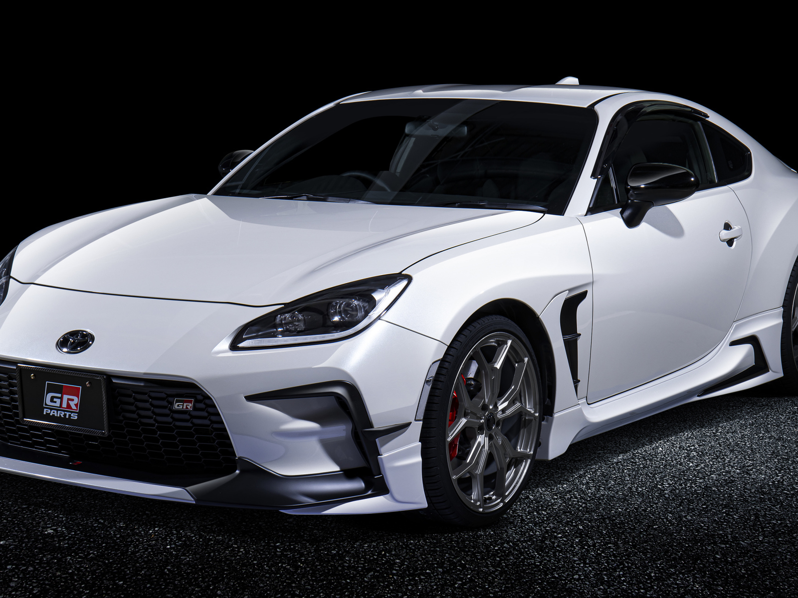 Белый автомобиль Toyota GR 86 GR With GR Parts 2021 года на черном фоне