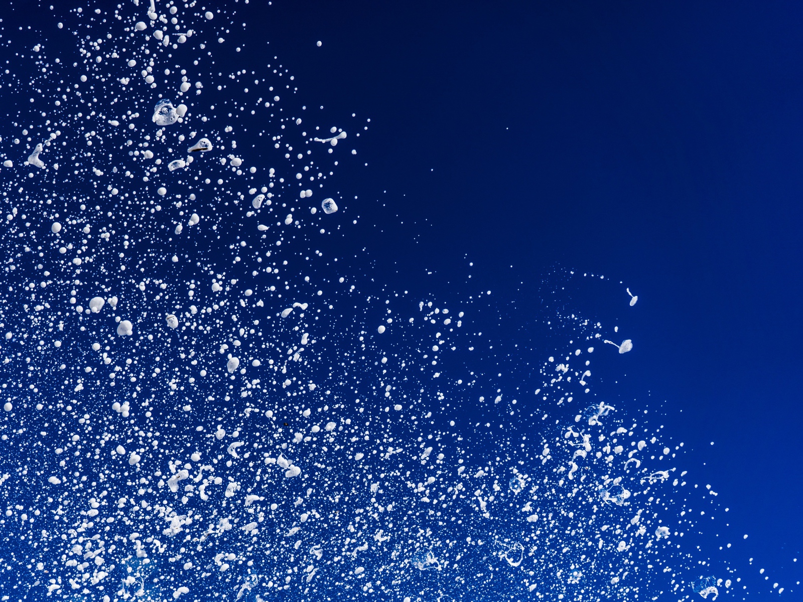 Белые брызги воды на синем фоне 