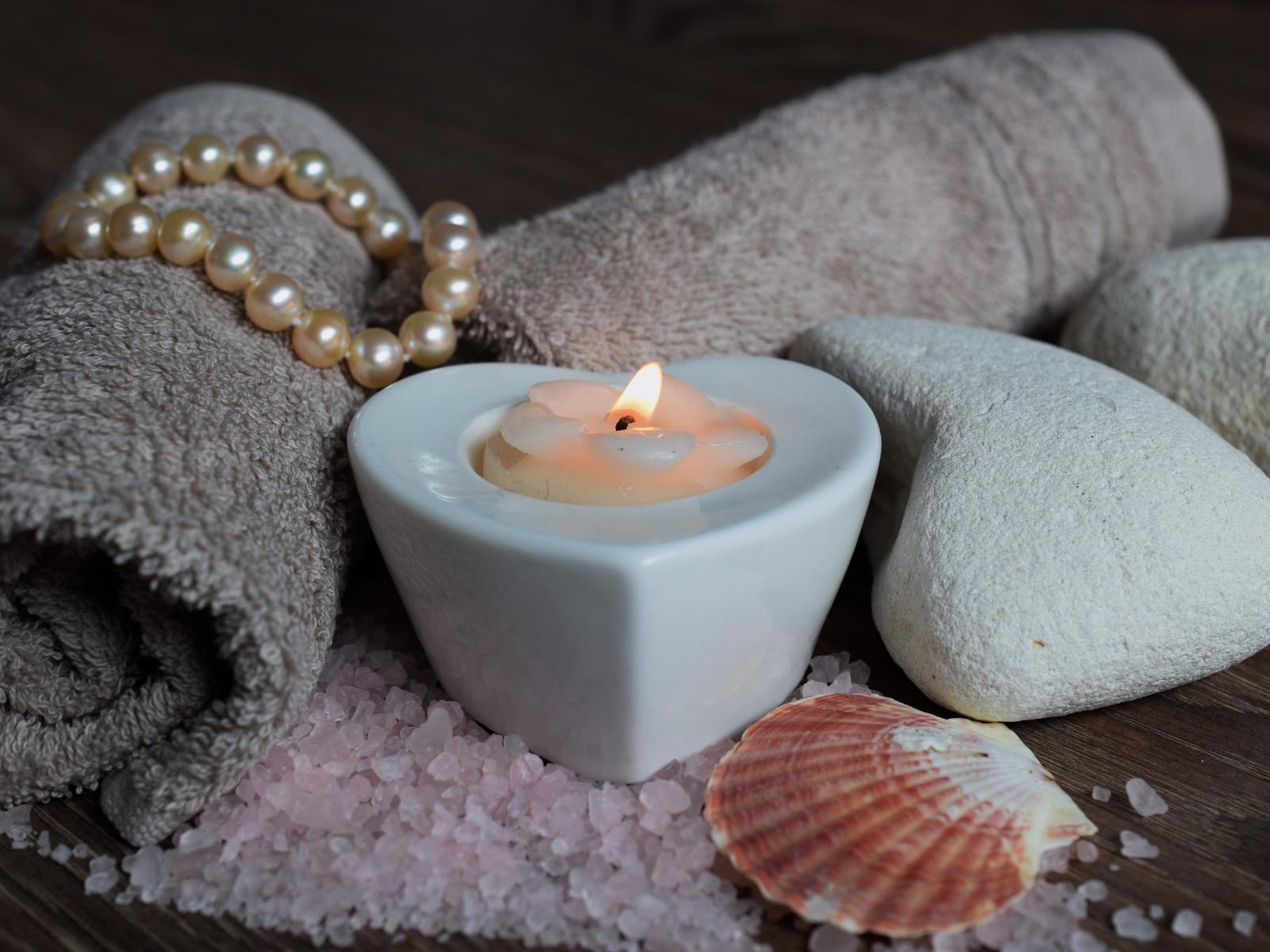 Красивая свеча с полотенцем, бусами, камнями и морской солью