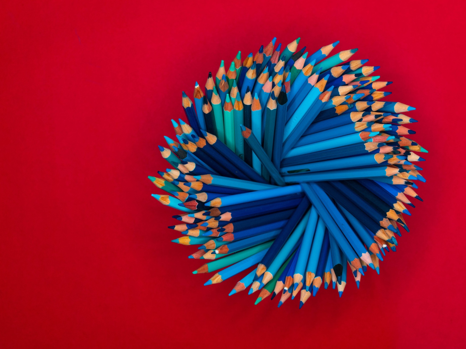 Синие карандаши на красном фоне