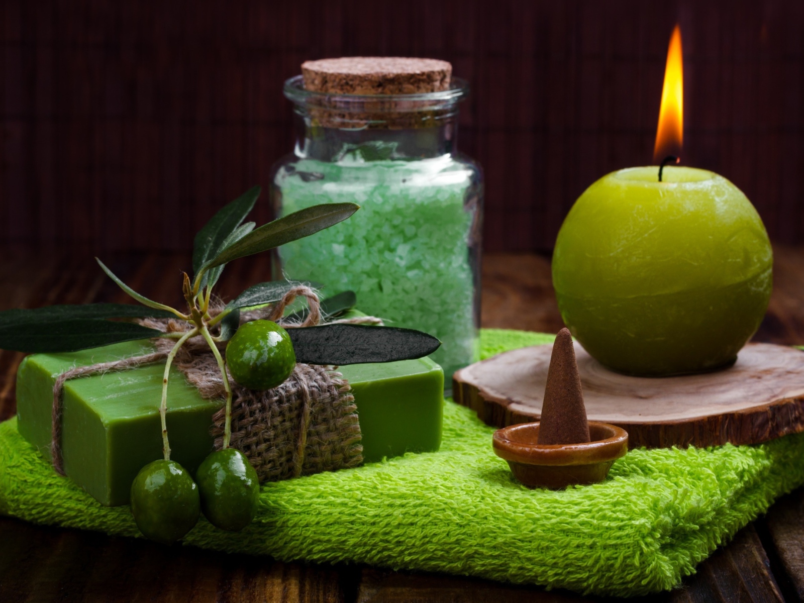 Зажженная свеча и мыло с оливками  и солью 