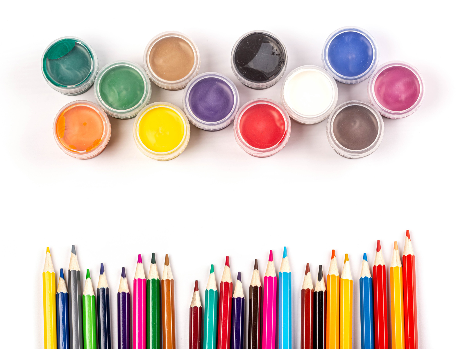 Разноцветные карандаши с красками  на белом фоне 