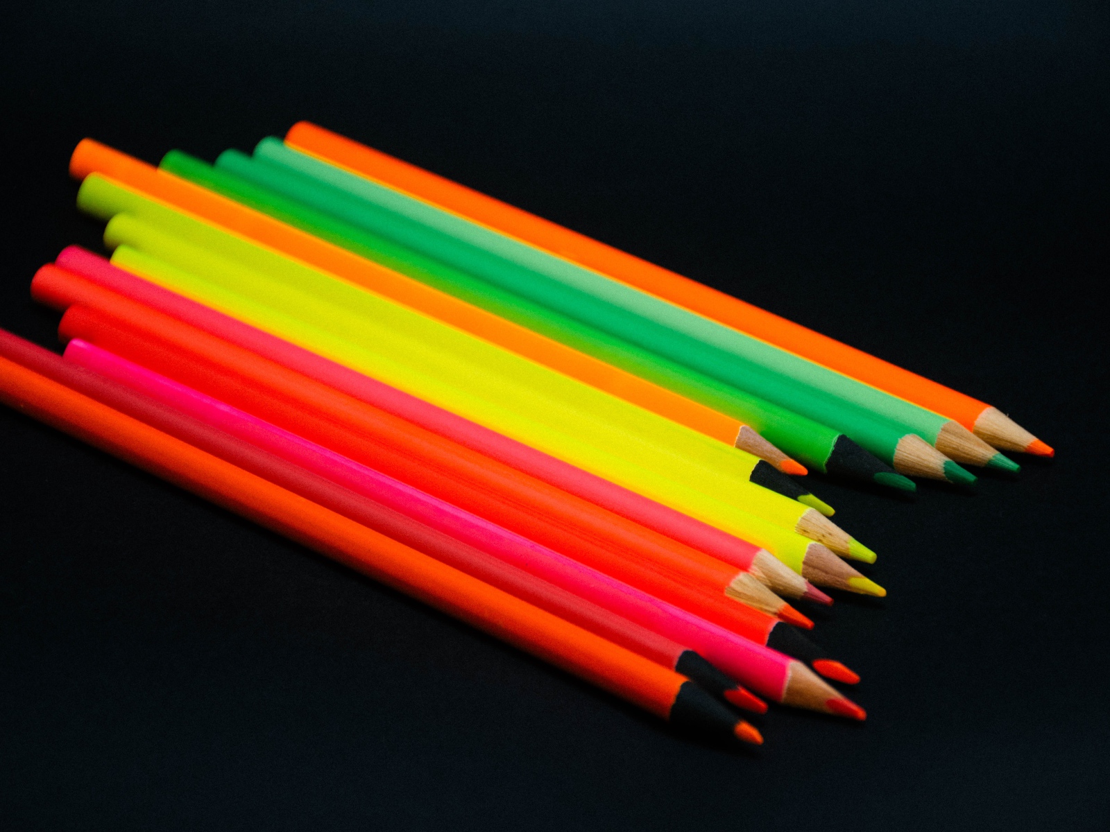 Палитра разноцветных карандашей на черном фоне