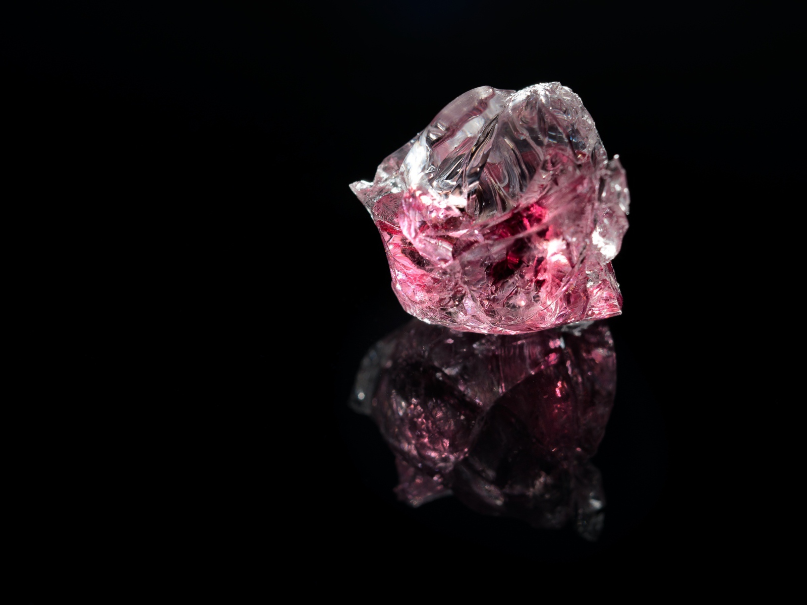 Розовый драгоценный камень на черном фоне 