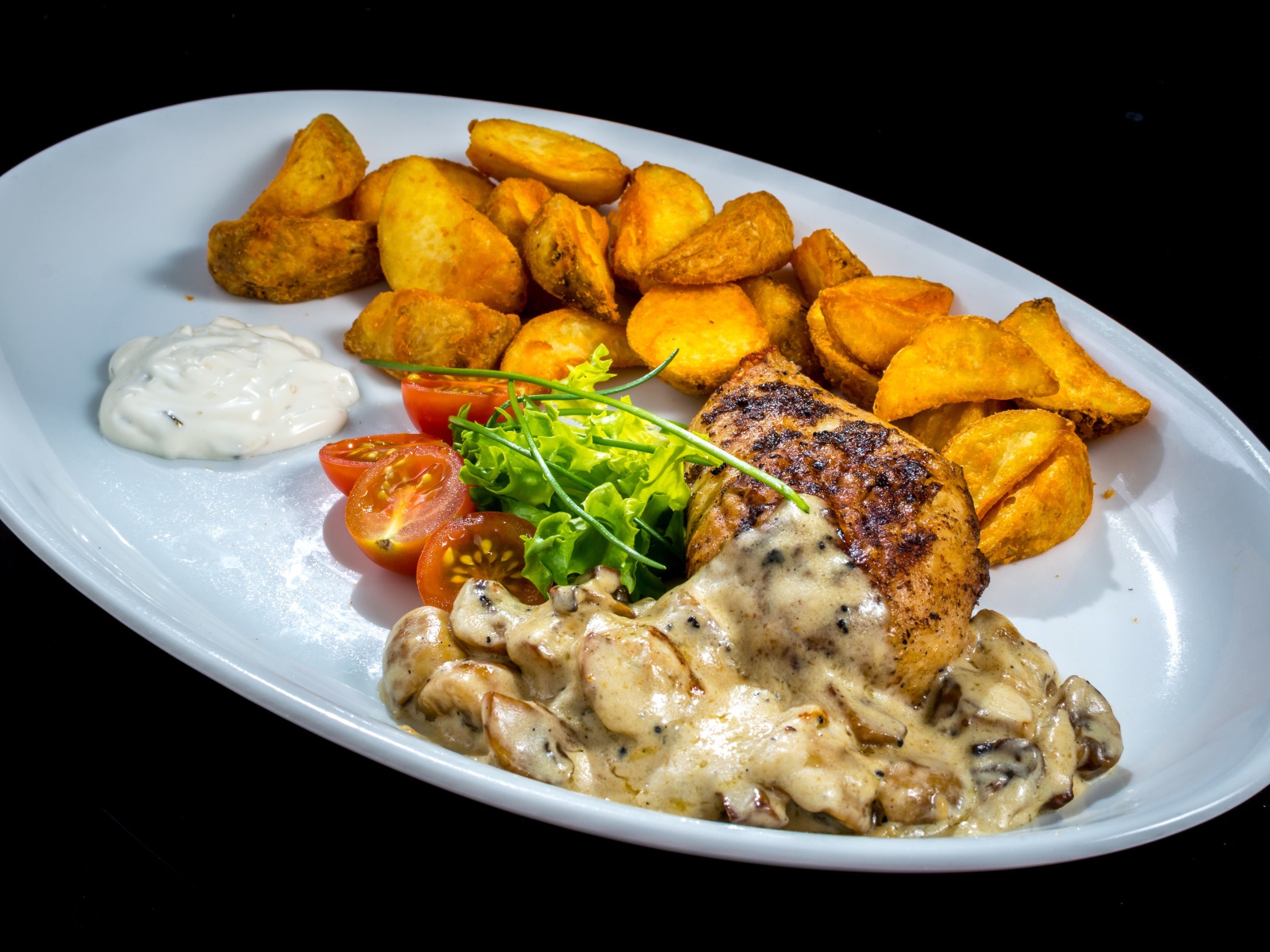 Запеченный картофель с грибами, мясом и овощами на тарелке