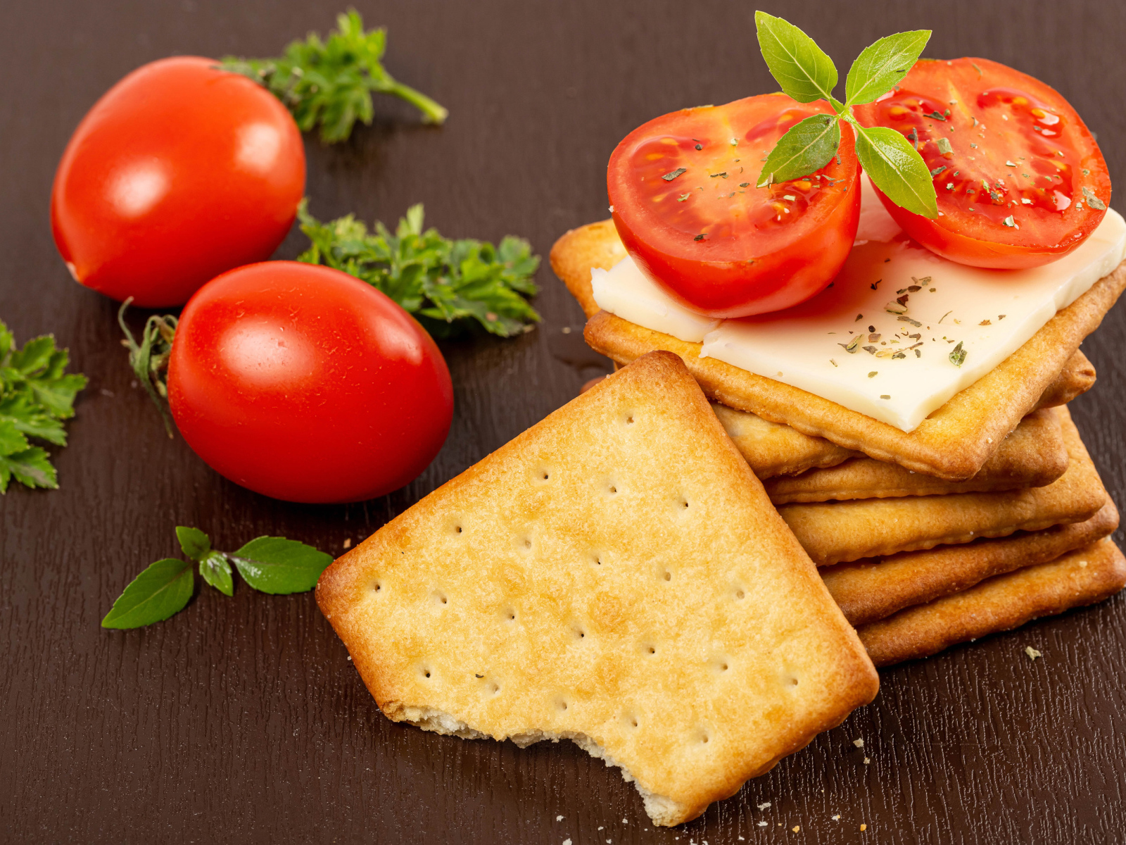 Печенье к крекер с помидорами на столе 