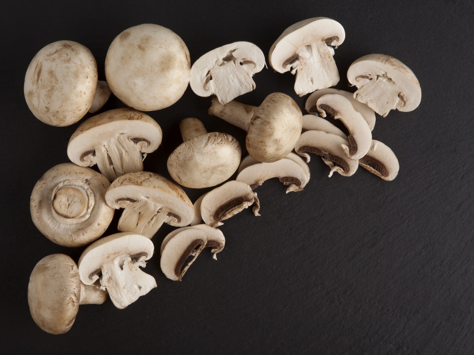 Свежие нарезанные шампиньоны на сером фоне