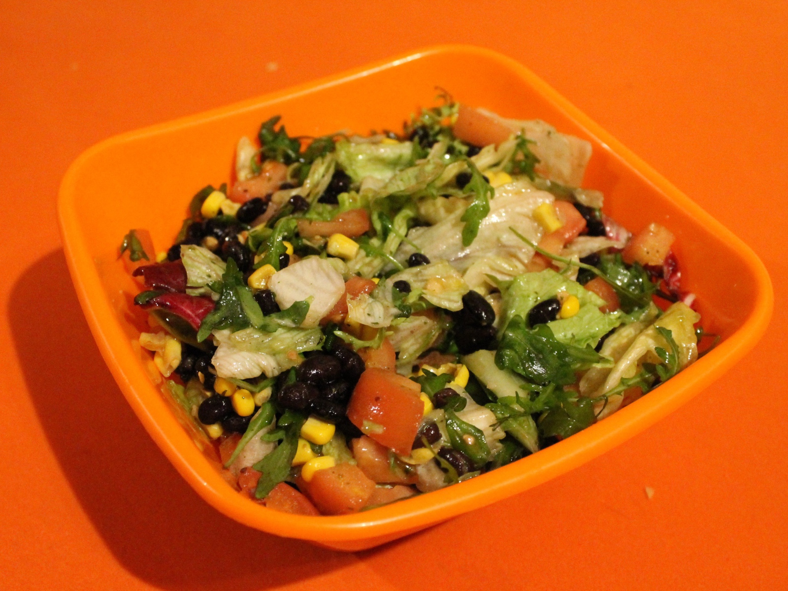 Салат из свежих овощей на оранжевом фоне