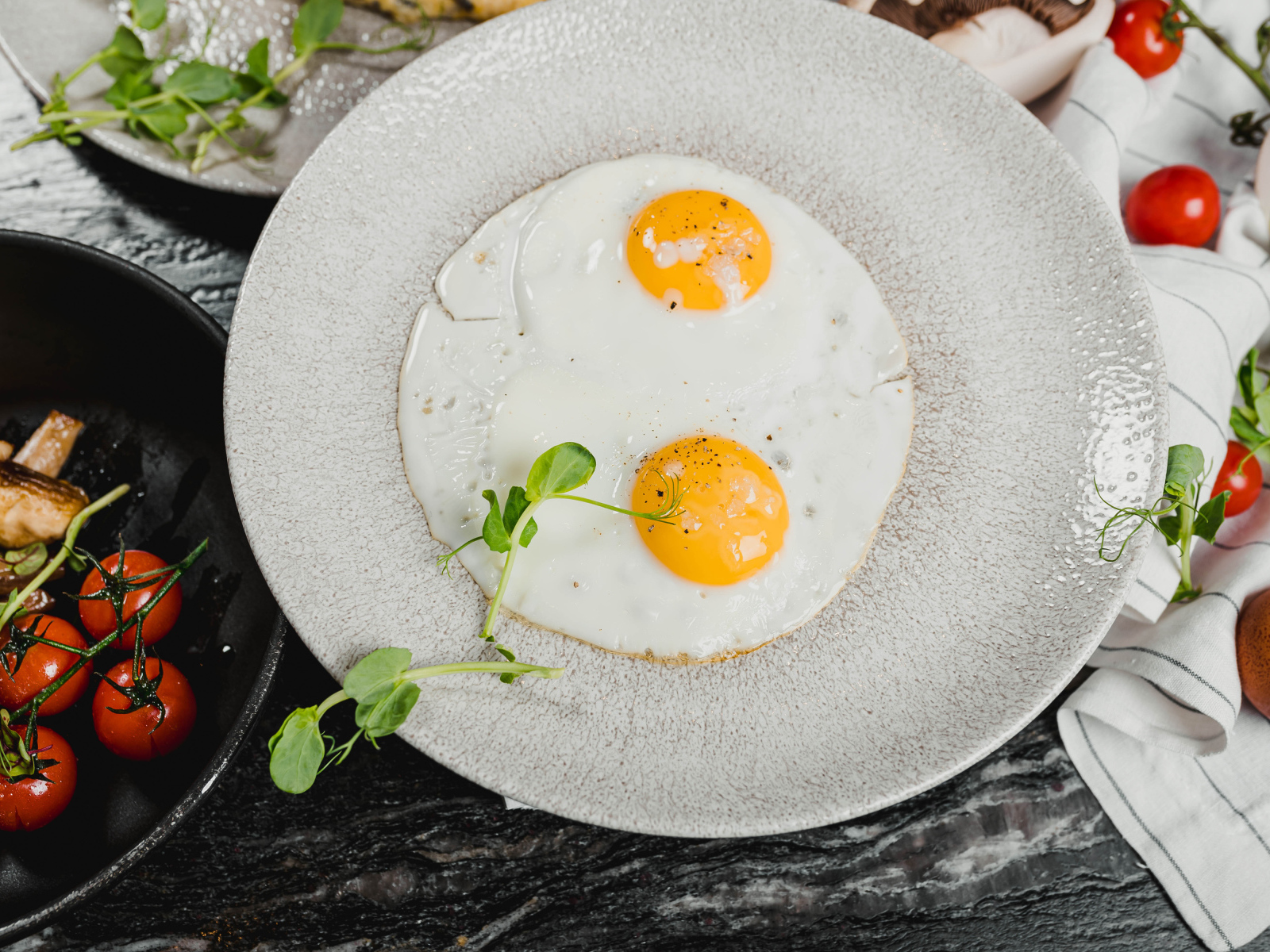 Яичница глазунья на большой серой тарелке