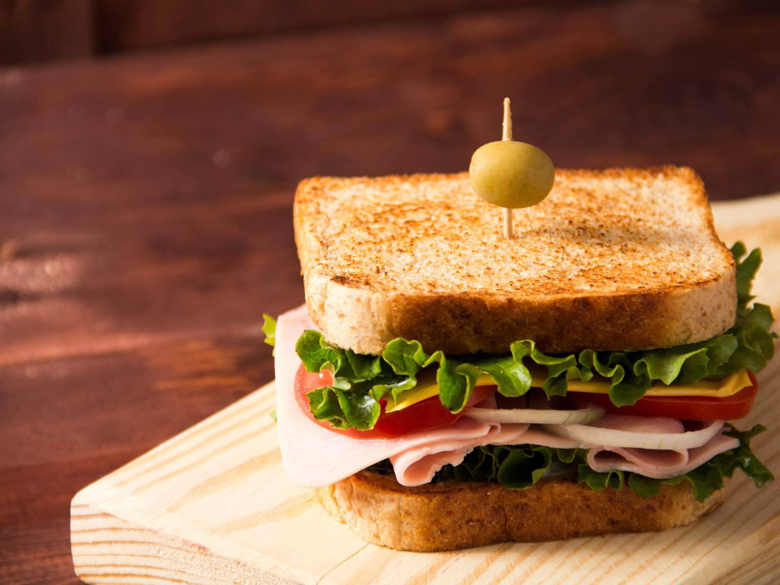 Гамбургер с ветчиной, помидорами, листьями салата и сыром