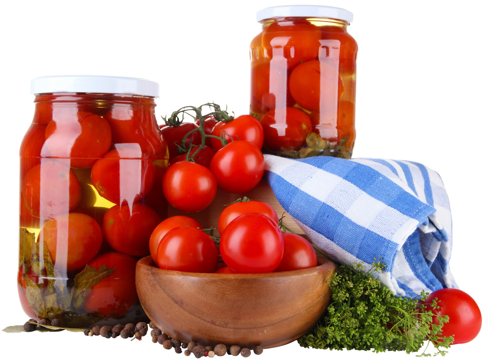 Маринованные помидоры в банках на столе со свежими